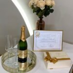 Kit do Curso de Microblading FP Elegance Brows com caixa dourada, certificado emoldurado, garrafa de espumante e dois flutes.